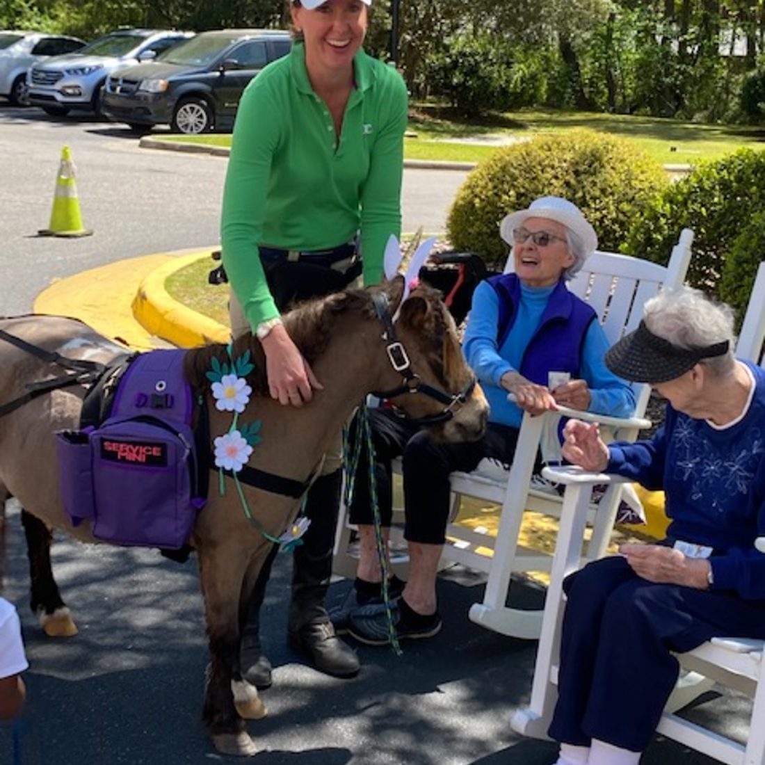 Danielle and Mister Waffles with laughing senior residents